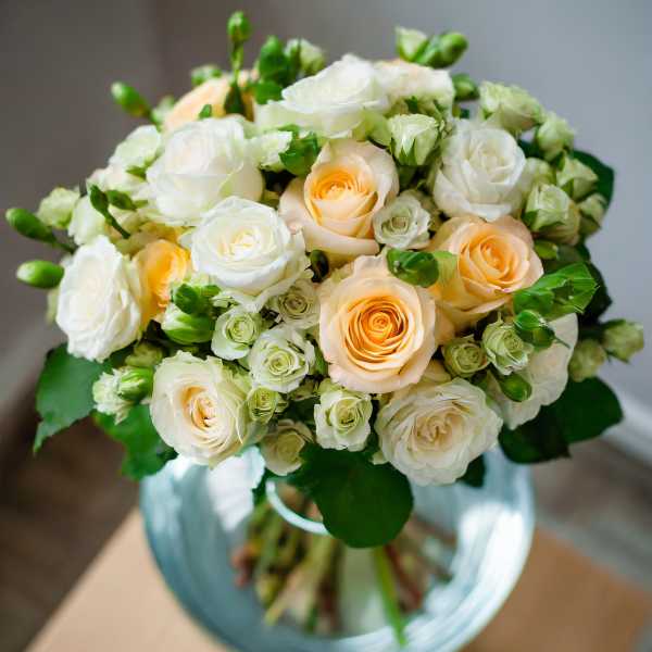 Bouquet of white and peach roses in a glass vase