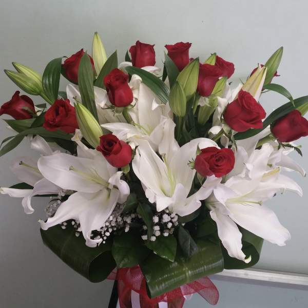 Bouquet of red roses and white lilies with a red ribbon