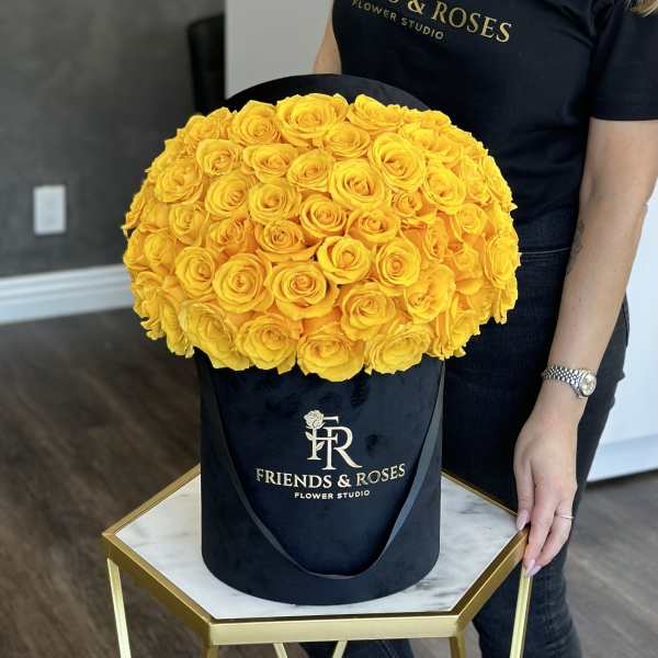 Large bouquet of yellow roses in a black hatbox