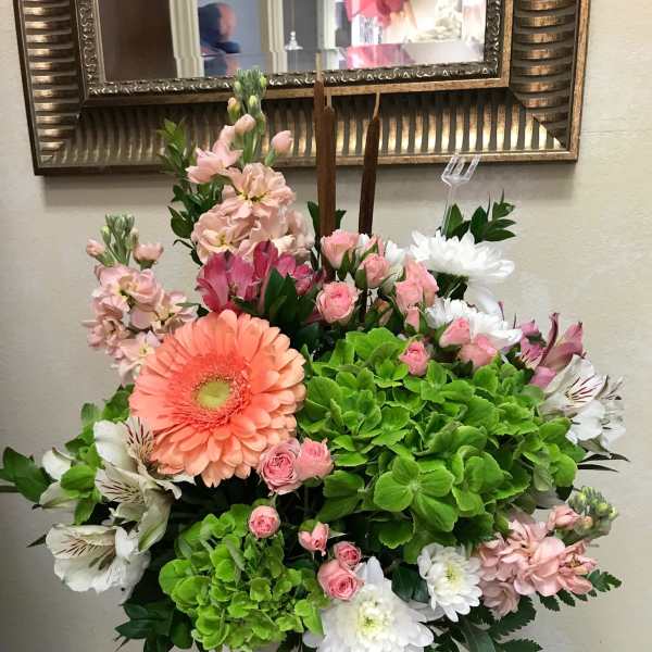 Mixed pink, white, and green floral arrangement in a speckled container