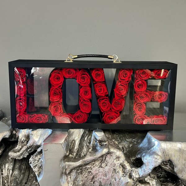 Black box display spelling LOVE filled with red roses