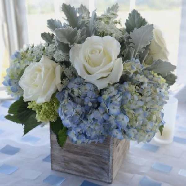 White roses and blue hydrangeas in a wooden box