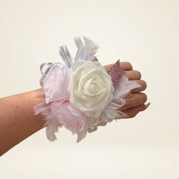 Wrist corsage with white and pale pink roses and ribbon accents