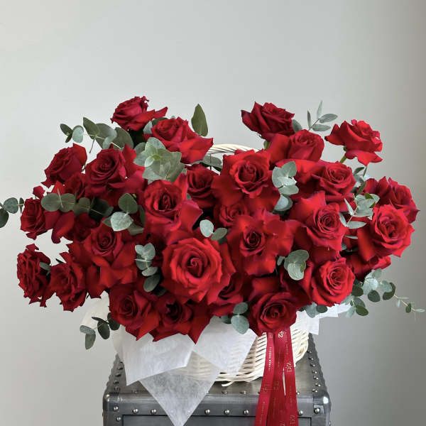Basket of red roses with eucalyptus