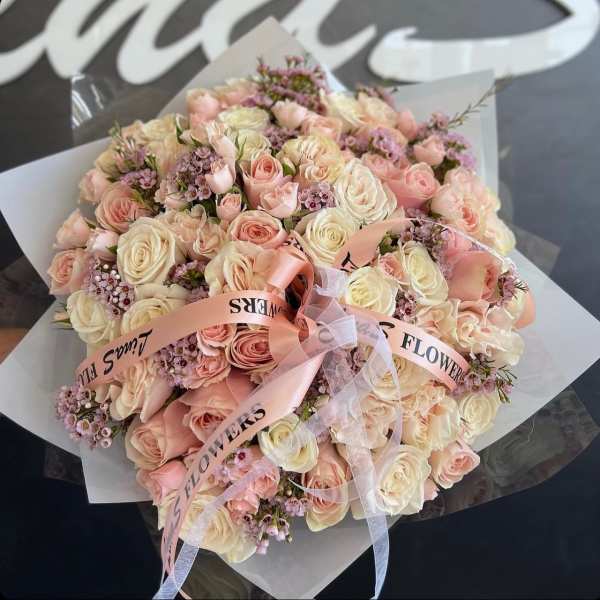 Large bouquet of pale pink and cream roses with ribbon