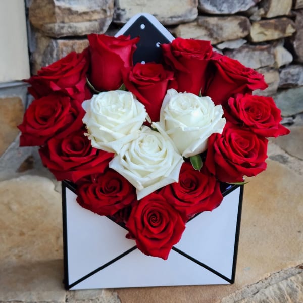 Red and white roses arranged in a black-and-white box