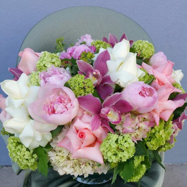 Pink and white bouquet with roses, peonies, and orchids