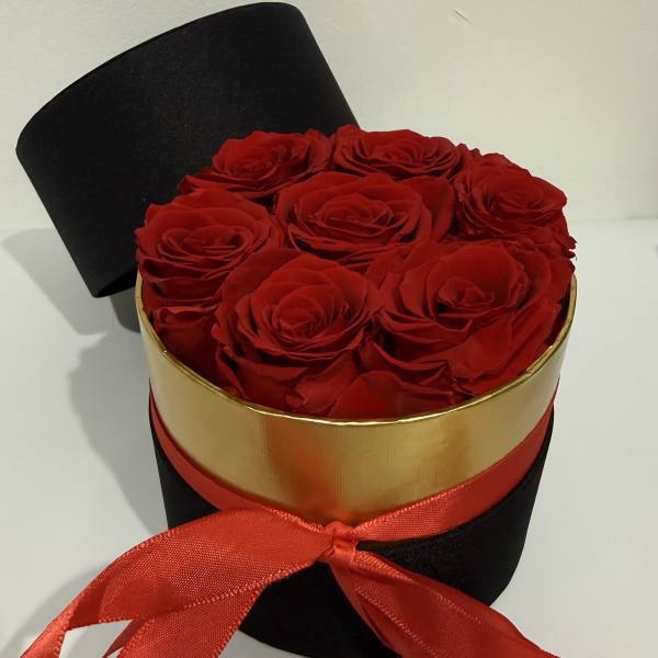 Red roses in a black round box with a red ribbon