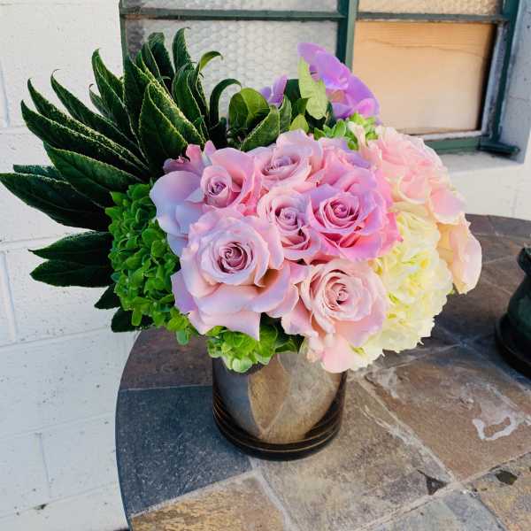 Pink roses and hydrangeas arranged in a black vase