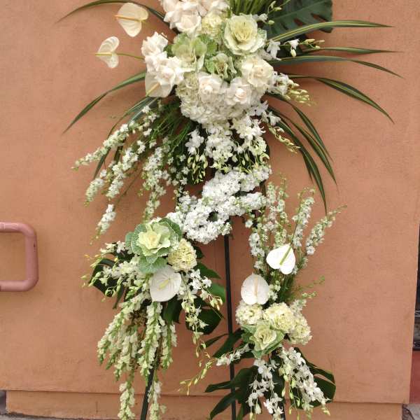 Tall white floral standing arrangement on a metal easel