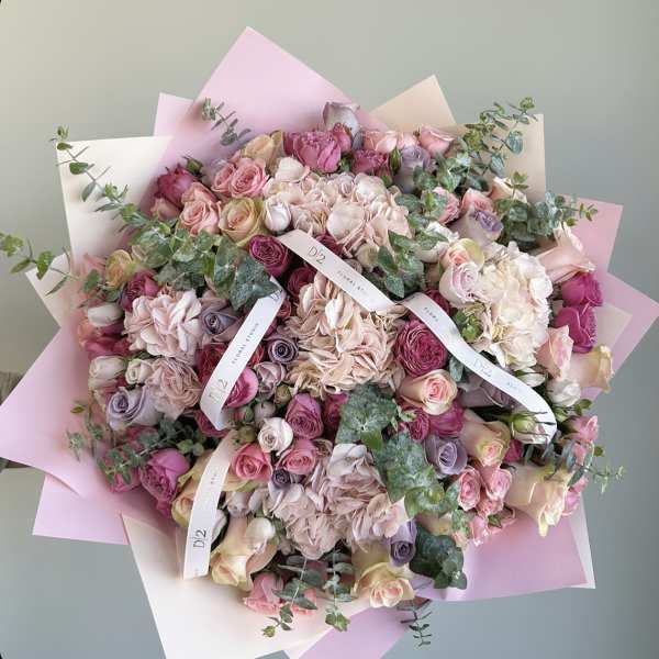Large bouquet of pink and cream roses with pastel wrapping