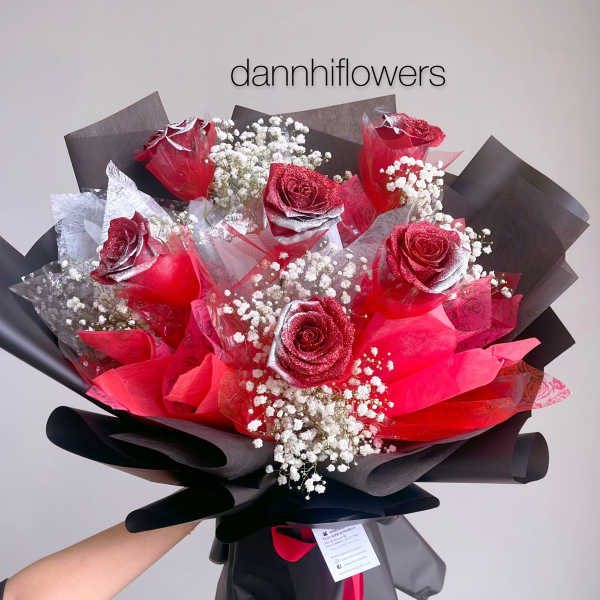 Bouquet of red roses with baby's breath wrapped in black paper