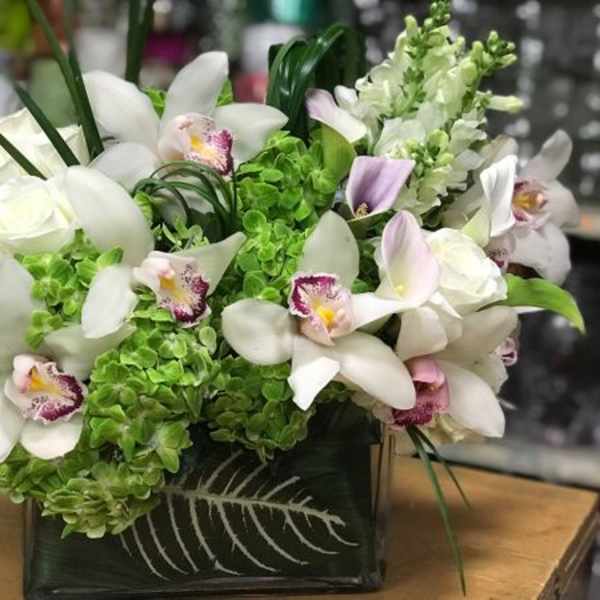 White orchids and roses in a black square vase