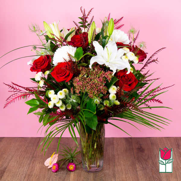 Bouquet of red roses and white lilies in a clear glass vase