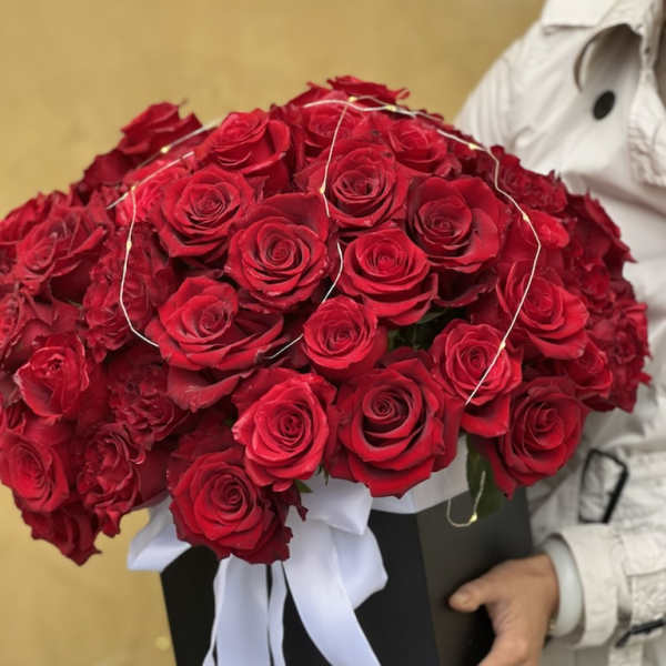 Large bouquet of red roses in a black box with a white ribbon