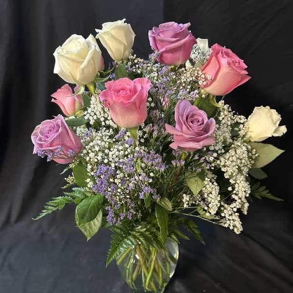 Bouquet of pink, lavender, and white roses in a glass vase