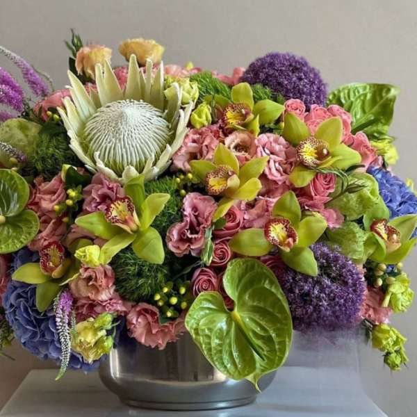 Colorful mixed floral arrangement in a silver bowl vase