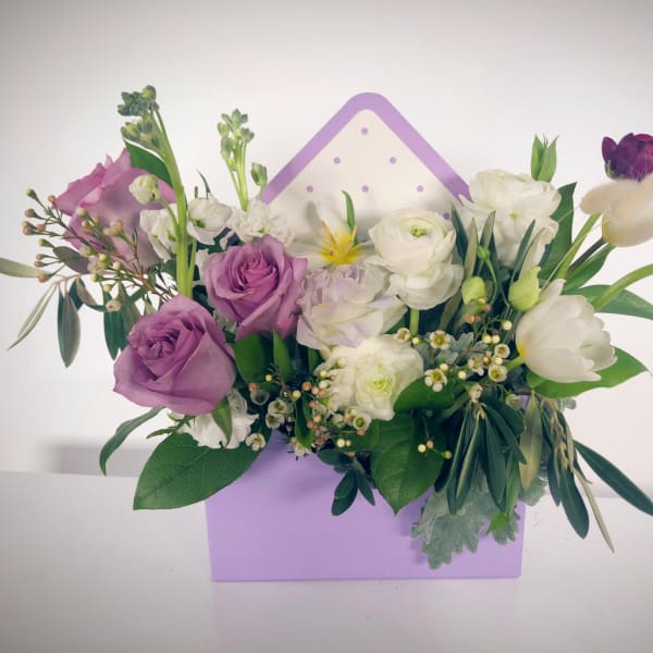 Purple and white mixed flower arrangement in a lavender box