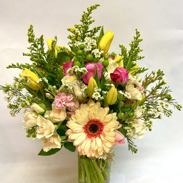 Mixed bouquet in a glass vase with pink and yellow flowers