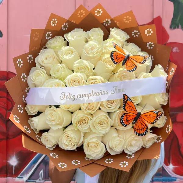 Bouquet of cream roses wrapped in brown paper with butterfly decorations
