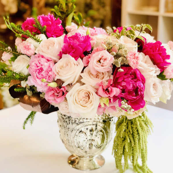 Pink and white rose bouquet in an ornate silver vase