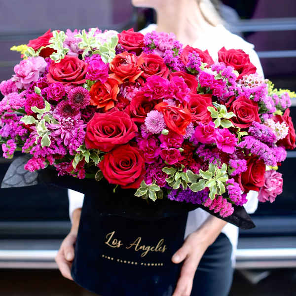 Large bouquet of red roses and pink flowers in a black box