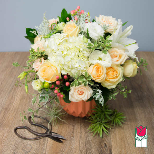 Peach and white rose bouquet in a peach vase
