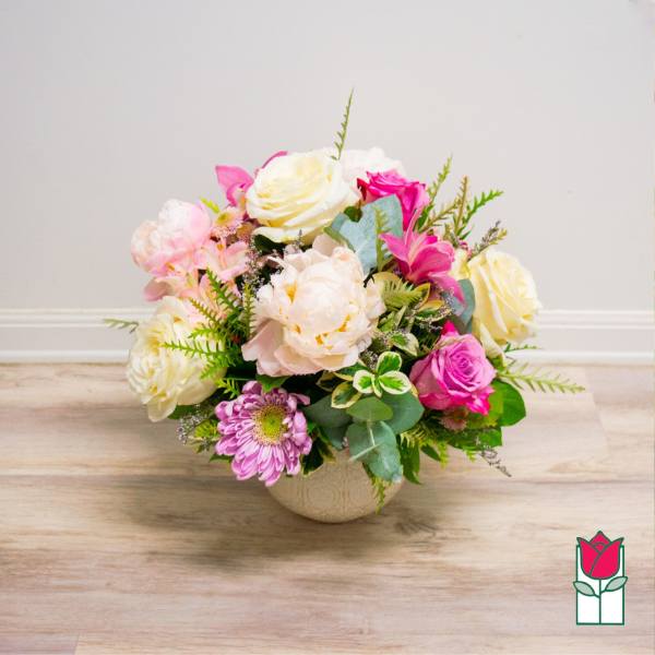 Mixed pink and white flower arrangement in a round vase