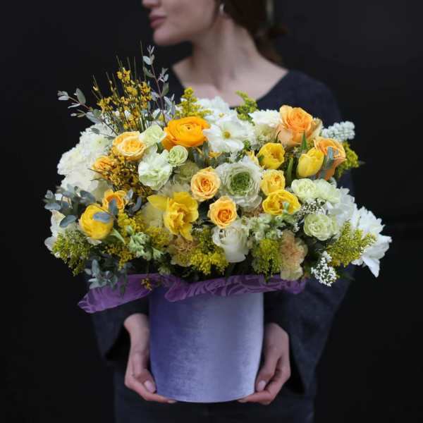 Large yellow and white flower arrangement in a purple hatbox