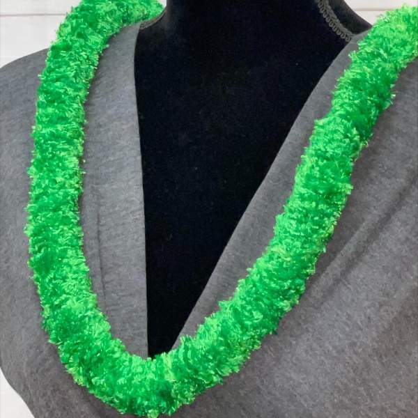 Bright green synthetic lei draped around the neck of a mannequin in a gray top