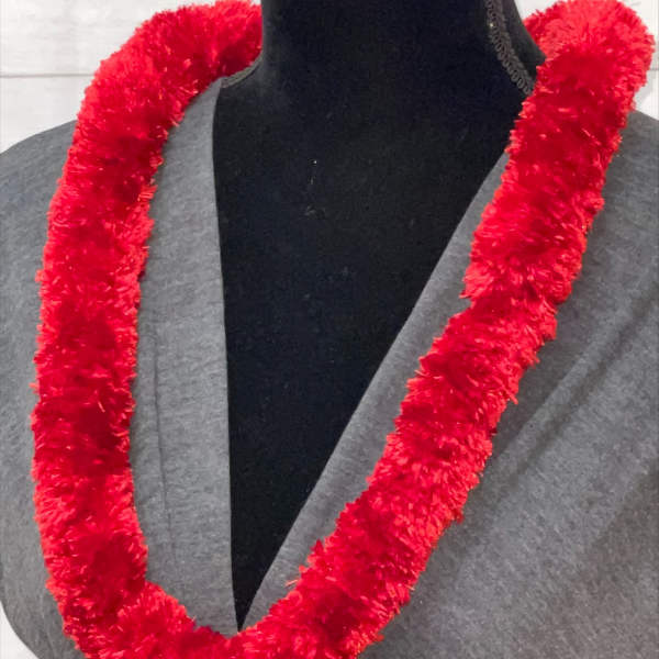 Fluffy red garland-style lei displayed on a black dress form in a gray top