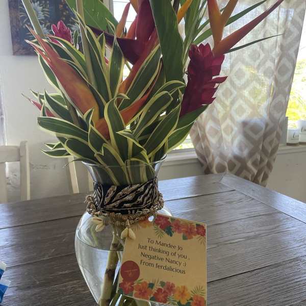 Tropical bouquet in a glass vase with a gift tag