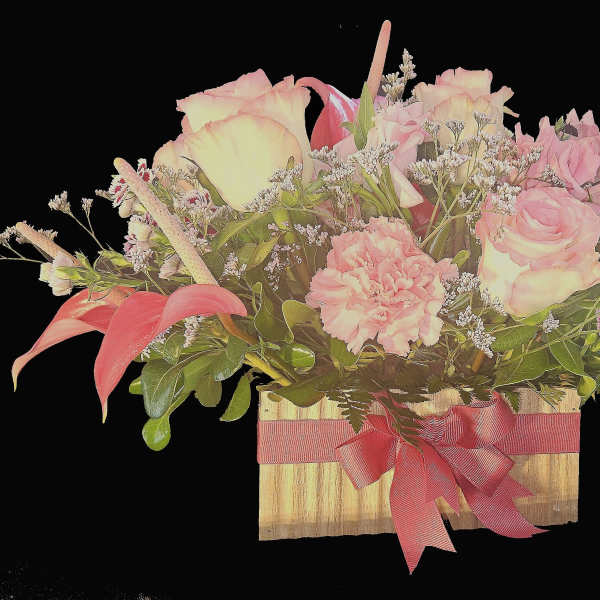 Low wooden box arrangement with pink roses, carnations, and mini calla lilies accented with small white blooms.
