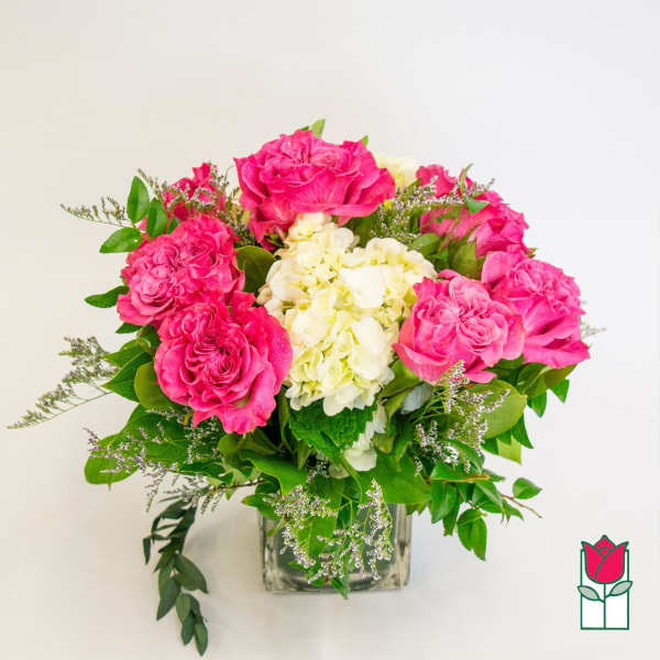 Pink roses and white hydrangeas in a clear glass vase