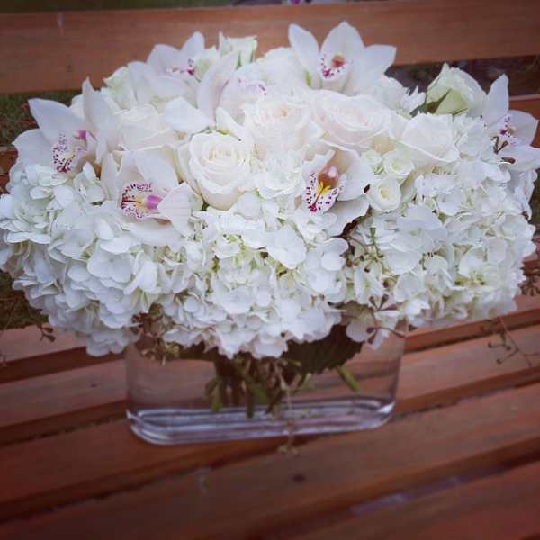 White floral arrangement in a clear rectangular vase