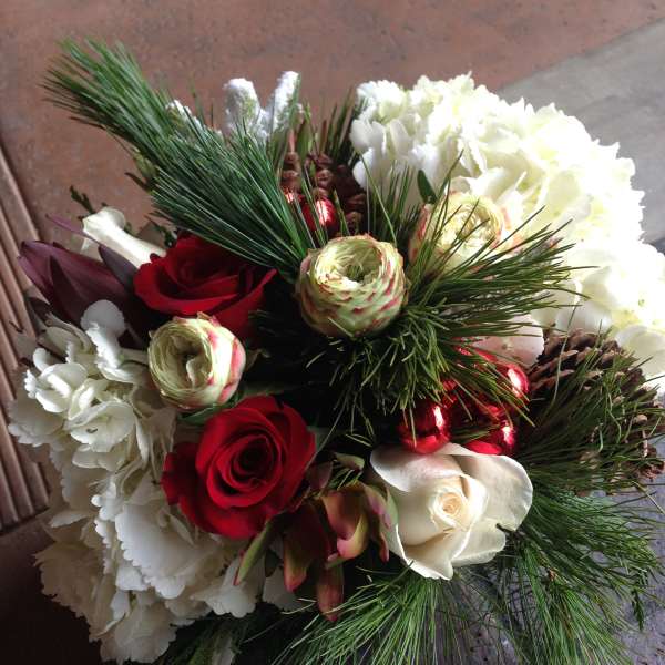 Bouquet of red and white roses with pine branches and pinecones