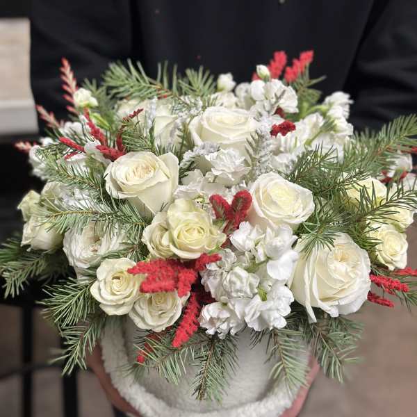White roses with red accents in a round container