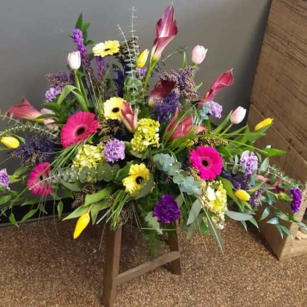 Large mixed floral arrangement with pink, yellow, purple, and white blooms