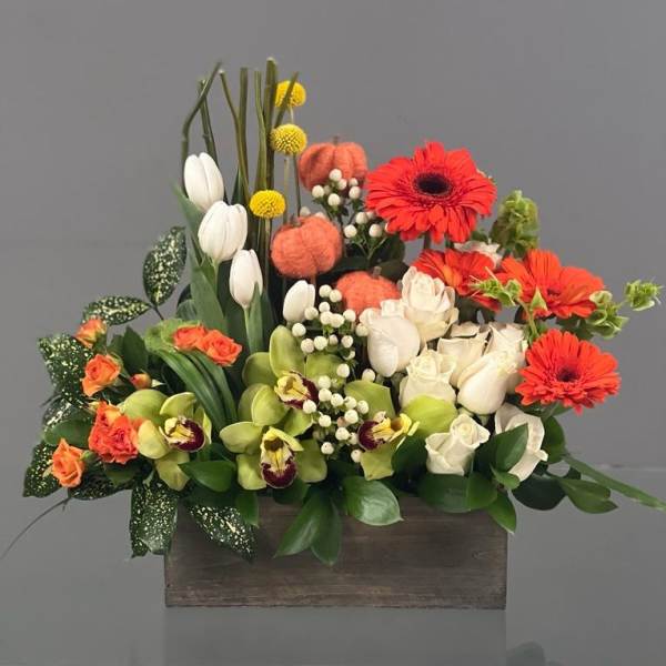 Mixed floral arrangement in a wooden box with white tulips and orange gerberas