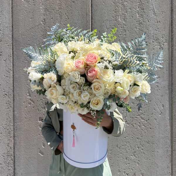 Large bouquet of cream and blush roses in a white hatbox