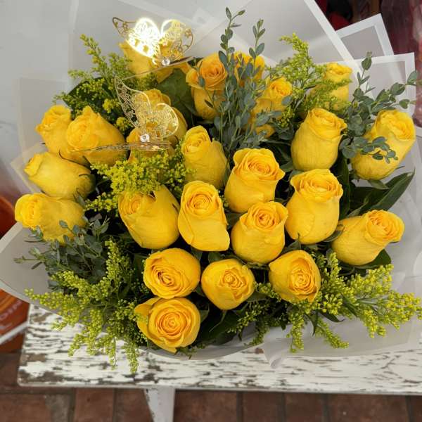 Bouquet of yellow roses with greenery and butterfly picks