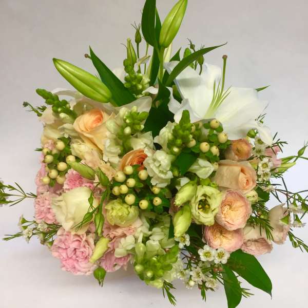 Bouquet of white lilies, peach roses, and pink blooms with green buds