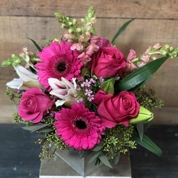 Pink roses and gerbera daisies in a square vase
