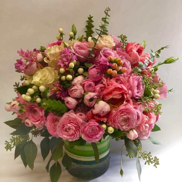 Pink and cream bouquet in a striped glass vase