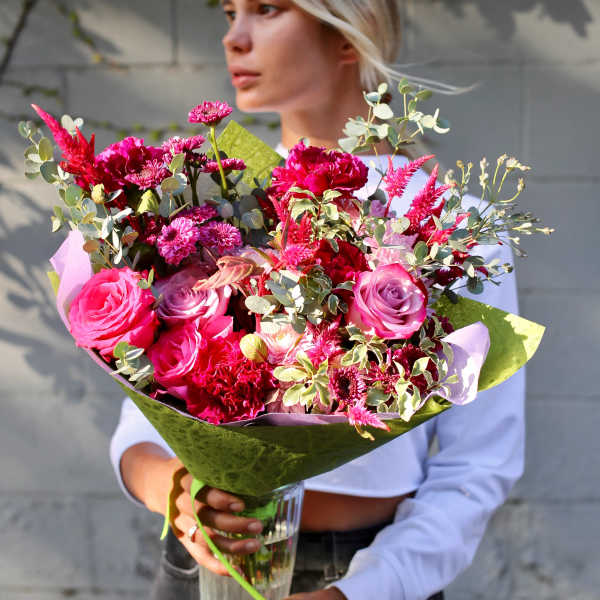Large bouquet of pink and magenta flowers in a glass vase