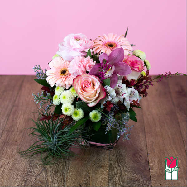 Pink and white mixed flower arrangement in a low square container