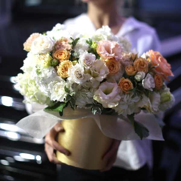 Large bouquet of white and peach roses in a gold box
