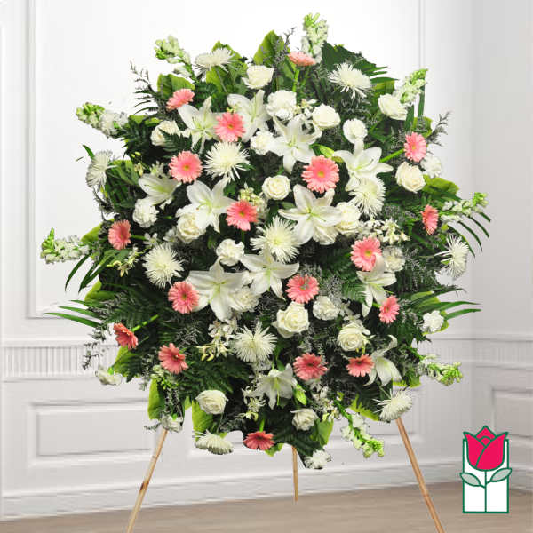 Large standing funeral spray with white and pink flowers on an easel