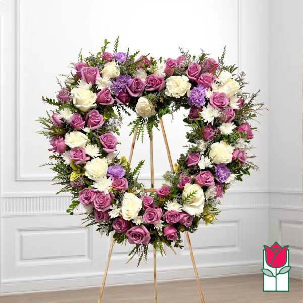 Heart-shaped floral wreath of pink, white, and purple roses on an easel