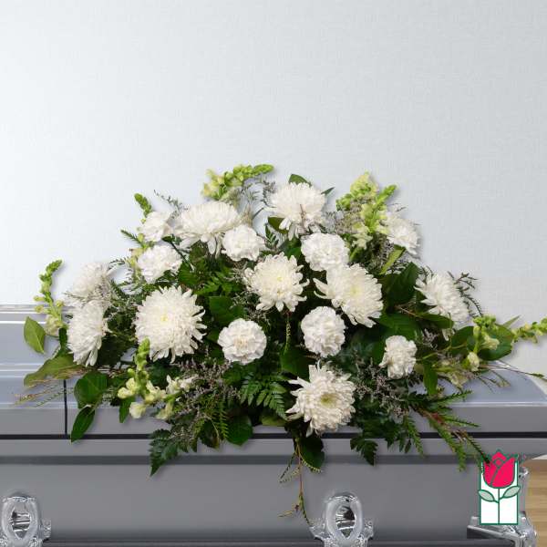 White floral casket spray with mixed blooms and greenery